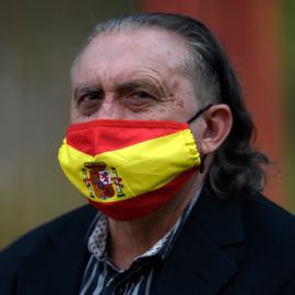  Una persona con una mascarilla con una bandera española asiste a la reunión de clausura de campaña del Partido Socialista Español (PSOE) para las pasadas elecciones regionales de Madrid, en Madrid el 2 de mayo de 2021.- AFP