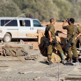 Los soldados israelíes revisan sus armas encima de un vehículo blindado de transporte de personal cerca de la frontera con Gaza, en el sur de Israel. REUTERS / Ronen Zvulun