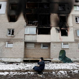 Una mujer, frente a un edificio gravemente dañado por los bombardeos rusos, en localidad de Volnovaja, en la región de Donetsk (Ucrania). REUTERS/Alexander Ermochenko