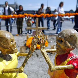  Transeuntes observan una Ofrenda de Muertos dedicada a los niños en el zócalo de Ciudad de Mexico, el 31 de octubre de 2003, como parte de las celebración del "Día de Muertos".- AFP