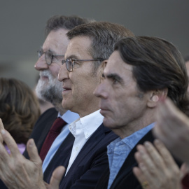 El presidente del PP, Alberto Núñez Feijóo, flanqueado por dos de sus predecesores, Mariano Rajoy y José María Aznar, aplauden durante la clausura de la 26 Intermunicipal del partido, en Valencia, en febrero de 2023. E.P./Jorge Gil