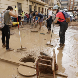 Vecinos y voluntarios colaboran en las labores de limpieza en la localidad de Paiporta este sábado tras el paso de la DANA.- EFE, Biel Aliño.