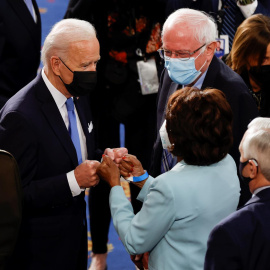 El presidente de los Estados Unidos, Joe Biden, saluda con el puño a la representante Maxine Waters mientras el senador Bernie Sanders observa tras el discurso del primero en la sesión conjunta del Congreso de los Estados Unidos en el Capitolio en Washi