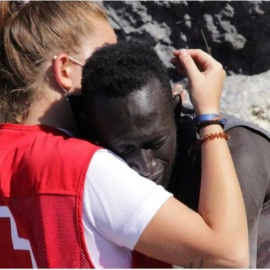  Imagen de un joven migrante, que acaba de llegar a Ceuta, abrazando a una voluntaria de Cruz Roja.