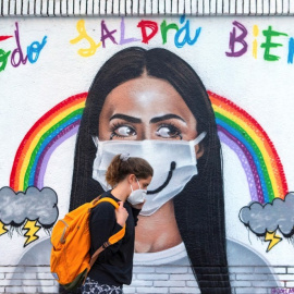  Una mujer pasea frente a un mural sobre la pandemia por covid-19. — EFE / ARCHIVO