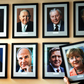  La imagen de la canciller alemana Angela Merkel está colgada en una pared con los retratos de los ex cancilleres alemanes (arriba, de izquierda a derecha) Konrad Adenauer, Ludwig Erhard, Kurt Georg Kiesinger, Willy Brandt, (abajo, de izquierda a derecha