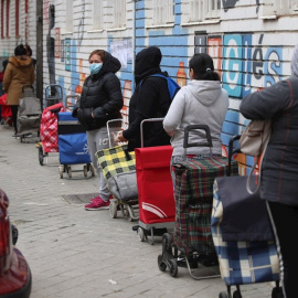  Varias personas esperan en la fila para recoger alimentos proporcionados por la Asociación de vecinos de Aluche. EFE.