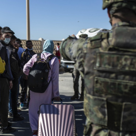  Una mujer que llevaba meses atrapada en Ceuta debido al cierre de fronteras impuesto por Marruecos para frenar la covid cruza el paso del Tarajal, aprovechando el regreso voluntario de cientos de jóvenes que cruzaron a nado hace dos días. — JAIRO V