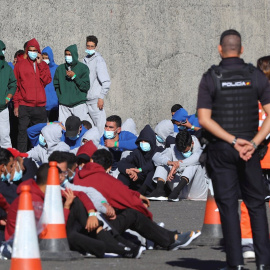 Varios inmigrantes descansan en el muelle de Arguineguín tras ser rescatados por Salvamento Marítimo, el pasado domingo, en Gran Canaria. — Elvira Urquijo A. / EFE