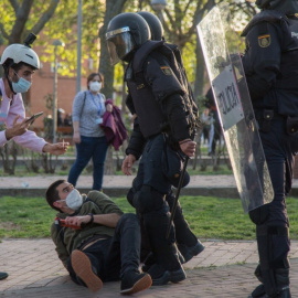 El periodista Guillermo Martínez, en el suelo junto a dos policías antidisturbios, el 7 de abril de 2021, día del mitin de Vox en Vallecas. – Fernando Capdepón Arroyo