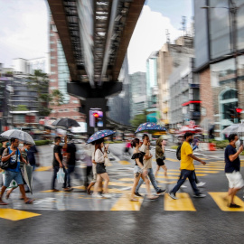 Los peatones con paraguas cruzan una intersección durante la lluvia cerca de los distritos comerciales de Kuala Lumpur (Malasia), a 15 de octubre de 2022. Foto: Wong Fok Loy / SOPA Images via ZUM / DPA