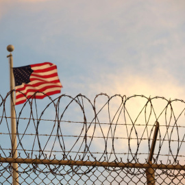  16 de octubre de 2018, Cuba, Bahía de Guantánamo: Una bandera de Estados Unidos ondea al viento detrás de una cerca de alambre de púas en el campo de detención de la Bahía de Guantánamo. Foto: Maren Hennemuth / dpa