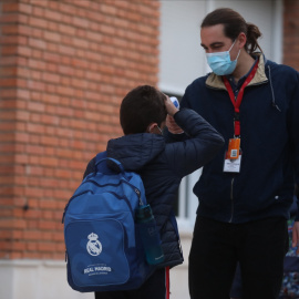  Un trabajador toma la temperatura a un niño a su llegada a clase presencial.- Isabel Infantes / Europa Press