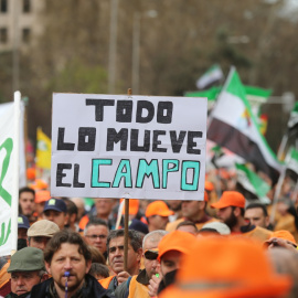  Varios manifestantes, con gorras naranjas con una pancarta que reza 'Todo lo mueve el campo', durante la la marcha por el mundo rural ‘20M’, a 20 de marzo de 2022, en Madrid (España).- Isabel Infantes / Europa Press