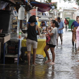 Diverses persones visiten un cementiri inundat a Kawit (Filipines) pels efectes d'un tifó. — Francis R. Malasig / EFE