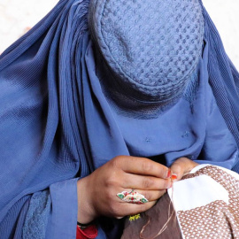  Una mujer afgana trabaja bordando ropa en un taller en Kandahar, Afganistán..- EFE