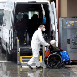 01/04/2020.- Trabajadores de la residencia Vitalia en Leganés, una de las varias residencias privadas de personas mayores que serán dirigidas por funcionarios, trasladan a una anciana no contagiada por coronavirus, este miércoles. La Consejería de Pol