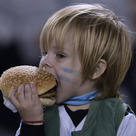 Un niño argentino se come una hamburguesa. Juan MABROMATA. AFP