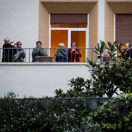 Un grupo de jubilados aplaude aplaude desde un balcón para agradecer el trabajo de los sanitarios que luchan contra la pandemia de coronavirus, en la decimoquinta jornada de estado de alarma. EFE/Javier Etxezarreta