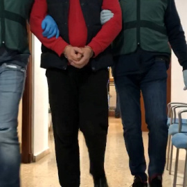 Los agentes conducen al exdiputado de la Duma Estatal rusa buscado por malversación tras su detención. / Guardia Civil