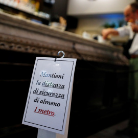 Un cartel en la barra de un bar en Roma pide que se guarde una distancia mínima de seguridad por la pandemia del coronavirus. REUTERS/Guglielmo Mangiapane