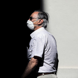 13/05/2020.- Una persona protegida con mascarilla recorre una calle en València, donde se mantiene la fase 0 en el sexagésimo día de estado de alarma. EFE/Ana Escobar