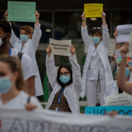 Decenas de miembros del personal sanitario protegidos con mascarilla sostienen carteles durante la concentración de sanitarios en el Día Internacional de la Enfermería a las puertas del Hospital Vall d'Hebron, en Barcelona. Europa Press / Archivo