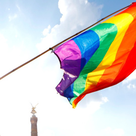 Una persona sostiene una bandera LGBT frente a la Columna de la Victoria de Berlín durante el desfile anual del Orgullo LGBT. REUTERS / Axel Schmidt / Archivo