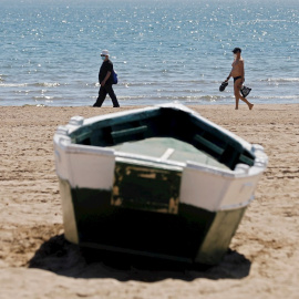 Cuatro personas disfrutan del buen tiempo y del calor en la playa de la Malvarrosa, el pasado viernes. EFE/Kai Försterling