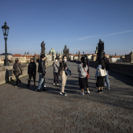 Turistas japoneses con mascarilla en el Puerte de Carlos, de Praga, en las primeras semanas de la pandemia por coronavirus. AFP/Michal Cizek