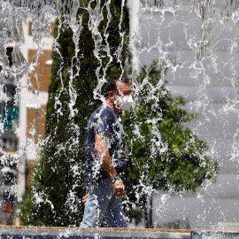 Un hombre camina este domingo por una fuente de Córdoba. /EFE