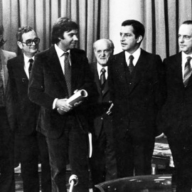 Adolfo Suárez y Felipe González se miran, flanqueados por Santiago Carrillo (izquierda), Manuel Fraga y los otros firmantes de los Pactos de la Moncloa, tras su rúbrica el 25 de octubre de 1977. | EFE