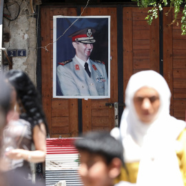 Varias personas pasan por una calle de Damasco, cerca de un retrato del presidente Sirio, Bashar al-Assad. AFP/LOUAI BESHARA