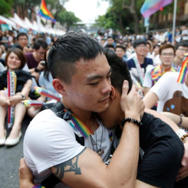 Dos integrantes de la comunidad LGBT (lesbianas, gais, bisexuales y transexuales) se abrazan mientras celebran la decisión del Tribunal Constitucional sobre el matrimonio entre personas del mismo sexo ante el Parlamento en Taipei / EFE