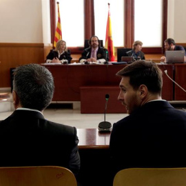 El jugador del FC Barcelona Lionel Messi y su padre, Jorge Horacio Messi, en la sala de la Audiencia de Barcelona durante la tercera jornada del juicio que se sigue contra ellos por tres delitos contra la Hacienda Pública. EFE/Alberto Estévez