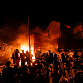 Los manifestantes se reúnen tras prender fuego a la entrada de una estación de policía mientras continúan las manifestaciones por George Floyd. REUTERS / Carlos Barria