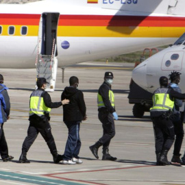 La Policía traslada hasta el avión a un grupo de inmigrantes que va a deportar desde Melilla.- EFE / ARCHIVO