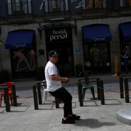 Un trabajador arrastra el soporte de una sombrilla para una terraza de una cafetería en el centro de Madrid. REUTERS/Susana Vera