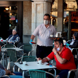 Un camarero sirve a los clientes en su bar de la Plaza Mayor de Salamanca. EFE/JM García