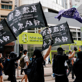 Unos manifestantes sostienen una bandera de independencia de Hong Kong mientras marcha contra la ley de seguridad nacional. REUTERS / Tyrone Siu