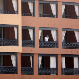 Un turista se asoma desde el balcón de su habitación en el hotel del sur de Tenerife. - EFE