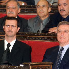 El presidente sirio Bashar al-Assad (izq.) y el ex vicepresidente Abdul-Halim Khaddam participan en una sesión del parlamento. Foto de archivo. Reuters