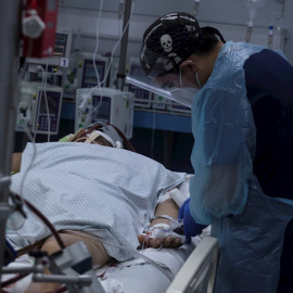 Fotografía de un sanitario que revisa el estado de un paciente afectado por covid-19. EFE/Alberto Valdés/Archivo