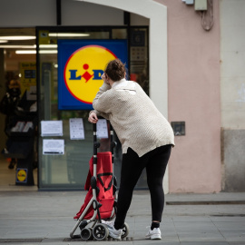 Una mujer espera con su carro de la compra a poder entrar a un supermercado Lidl , en Barcelona. E.P./David Zorrakino