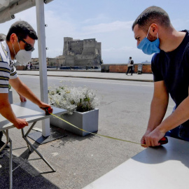 19/05 / 2020.- Los miembros del personal organizan de un establecimiento en el paseo marítimo de Caracciolo en Nápoles, Italia. / EFE - CIRO FUSCO