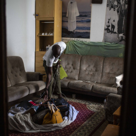 Samba, senegalés de 28 años, muestra el el salón de su casa de Lavapiés la manta con los bolsos que no ha podido vender en la calle durante el confinamiento decretado por el coronavirus.-  JAIRO VARGAS