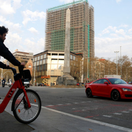 Un home espera creuar en bicicleta el pas de vianants, a tocar de la plaça Cinc d'Oros de Barcelona. ACN/Blanca Blay