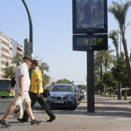 Dos personas pasan junto a un termómetro en Córdoba. - EFE