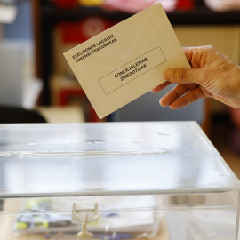  Personal con un sobre y una urna electoral en un colegio electoral de Bilbao, donde este domingo se vota a los municipios y a las diputaciones en el País Vasco. — EFE/Luis Tejido