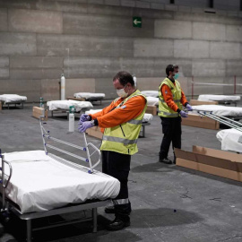 Operarios ayudando a construir el hospital de campaña en el Ifema de Madrid. / EFE